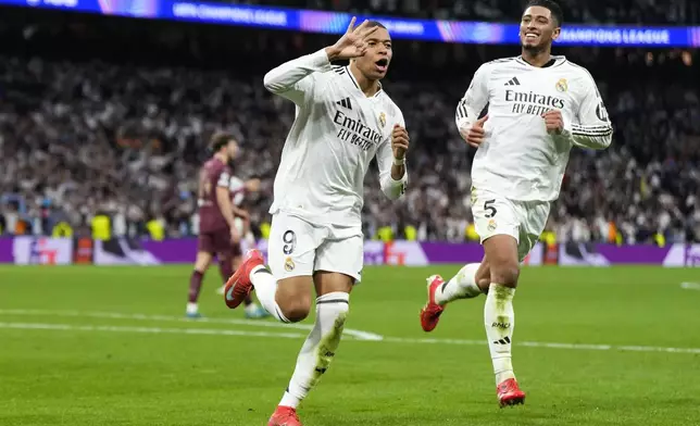 Real Madrid's Kylian Mbappe celebrates with Real Madrid's Jude Bellingham, right, after scoring his sides third goal during the Champions League playoff second leg soccer match between Real Madrid and Manchester City at the Santiago Bernabeu Stadium in Madrid, Spain, Wednesday, Feb. 19, 2025. (AP Photo/Manu Fernandez)