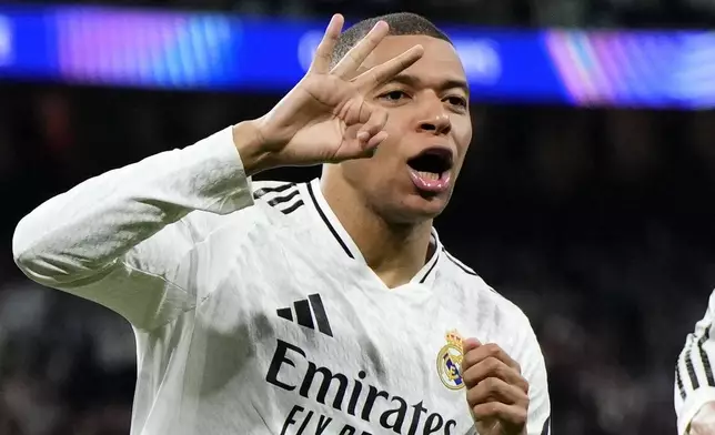 Real Madrid's Kylian Mbappe celebrates with Real Madrid's Jude Bellingham, right, after scoring his sides third goal during the Champions League playoff second leg soccer match between Real Madrid and Manchester City at the Santiago Bernabeu Stadium in Madrid, Spain, Wednesday, Feb. 19, 2025. (AP Photo/Manu Fernandez)