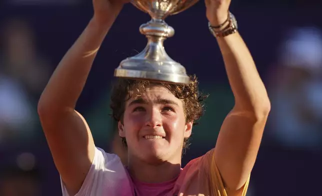 Brazil's Joao Fonseca poses with the trophy after defeating Argentina's Francisco Cerundolo during a men's doubles final match at the Argentina Open ATP tennis tournament at Guillermo Vilas Stadium in Buenos Aires, Argentina, Sunday, Feb. 16, 2025. (AP Photo/Gustavo Garello)