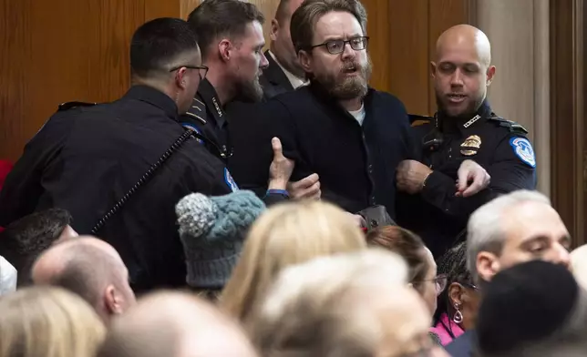 A protester saying he is a teacher is removed while calling out against the nomination of Linda McMahon, President Donald Trump's nominee for Secretary of Education, during a Senate Health, Education, and Labor Committee hearing on McMahon's nomination, Thursday, Feb. 13, 2025, in Washington. (AP Photo/Jacquelyn Martin)