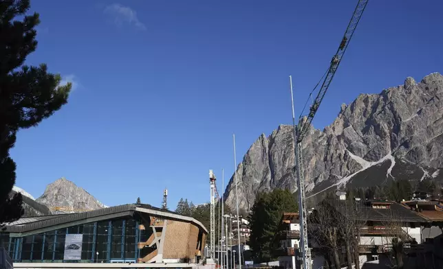 A crane is see by the Stadio Olimpico del Ghiaccio, which will be called Cortina Curling Olympic Stadium, venue for the curling discipline at the Milan Cortina 2026 Winter Olympics, in Cortina d'Ampezzo, Italy, Thursday, Jan. 16, 2025. (AP Photo/Giovanni Auletta)
