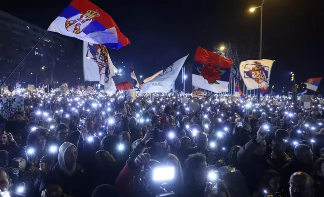 People hold up their mobile phone lights during a protest over the collapse of a concrete canopy that killed 15 people more than two months ago, in Novi Sad, Serbia, Saturday, Feb. 1, 2025. (AP Photo/Armin Durgut)