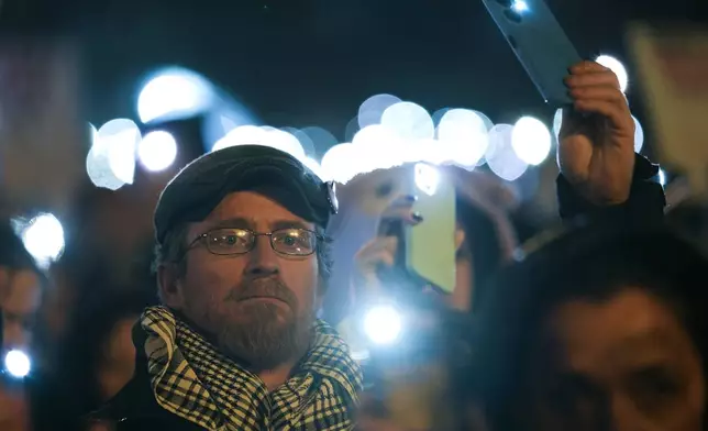 People hold up their mobile phone lights as tens of thousands gather for a protest over the collapse of a concrete canopy that killed 15 people more than two months ago, in Novi Sad, Serbia, Saturday, Feb. 1, 2025. (AP Photo/Darko Vojinovic)