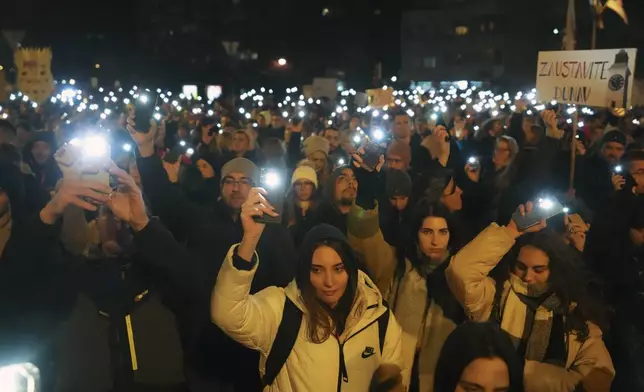People hold up their mobile phone lights as tens of thousands gather for a protest over the collapse of a concrete canopy that killed 15 people more than two months ago, in Novi Sad, Serbia, Saturday, Feb. 1, 2025. (AP Photo/Darko Vojinovic)