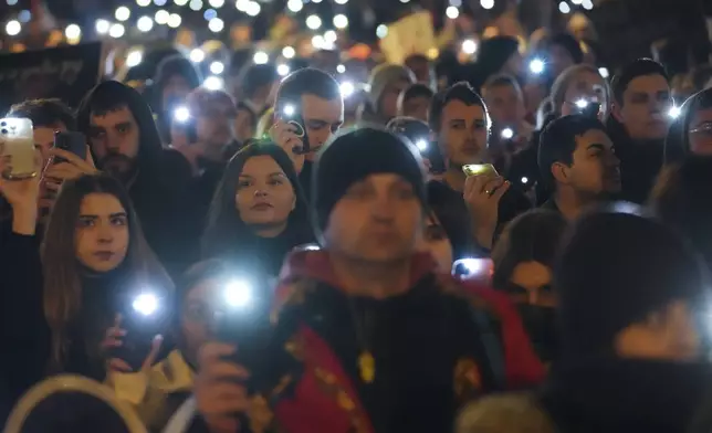 People hold up their mobile phone lights as tens of thousands gather for a protest over the collapse of a concrete canopy that killed 15 people more than two months ago, in Novi Sad, Serbia, Saturday, Feb. 1, 2025. (AP Photo/Darko Vojinovic)