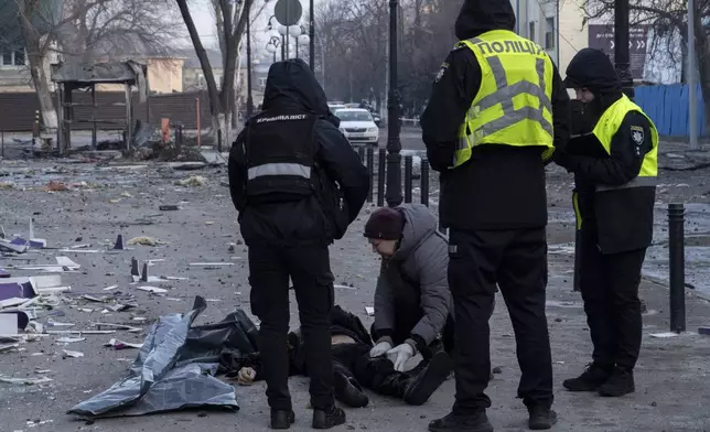 Police workers observe the body of a man killed after a Russian attack in Kyiv, Ukraine, Wednesday, Feb. 12, 2025. (AP Photo/Alex Babenko)
