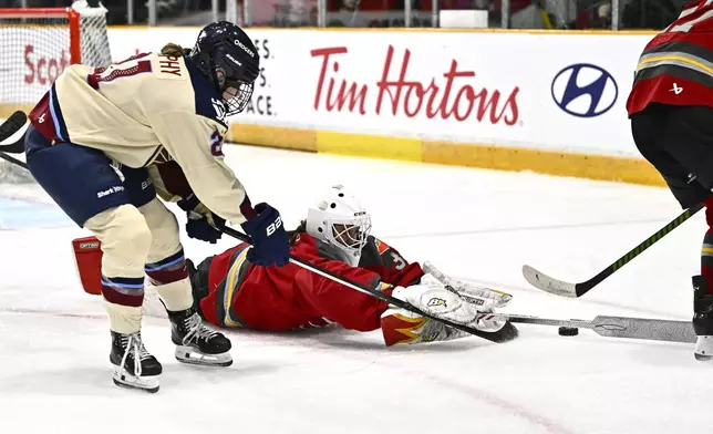 Ottawa Charge goaltender Gwyneth Philips (33) tries to keep the puck from Montreal Victoire's Maureen Murphy (21) after coming out from her crease to play the puck, during second period PWHL hockey action in Ottawa, on Saturday, Feb. 22, 2025. (Justin Tang/The Canadian Press via AP)