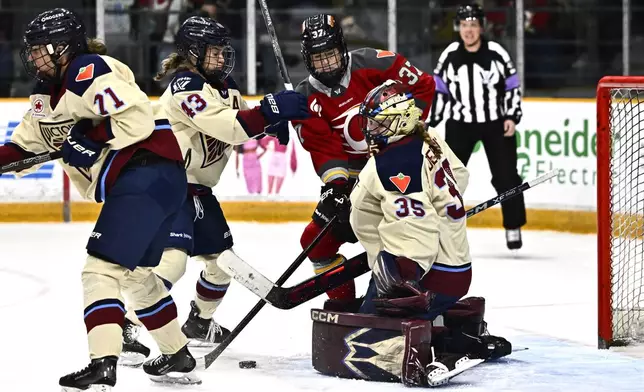 Montreal Victoire goaltender Ann-Renee Desbiens (35) makes a save as Victoire's Kristin O'Neill (43) tries to prevent Ottawa Charge's Rebecca Leslie (37) from getting a chance at the rebound, during first period PWHL hockey action in Ottawa, on Saturday, Feb. 22, 2025. (Justin Tang/The Canadian Press via AP)