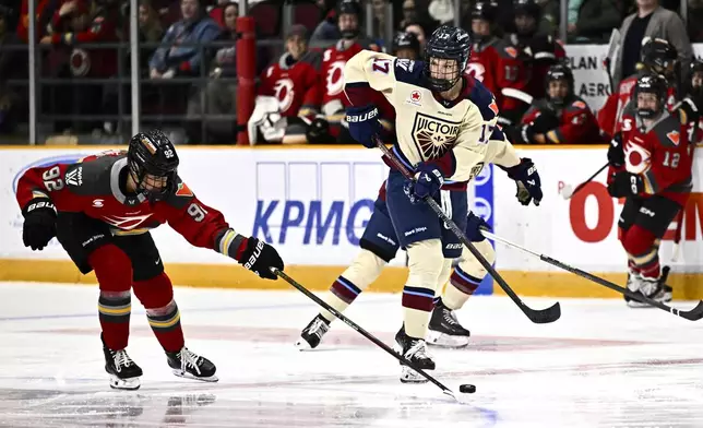 Ottawa Charge's Danielle Serdachny (92) pokes the puck from Montreal Victoire's Dara Greig (17) during second period PWHL hockey action in Ottawa, on Saturday, Feb. 22, 2025. (Justin Tang/The Canadian Press via AP)