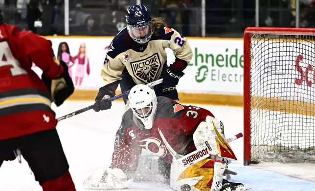 Montreal Victoire's Abigail Boreen (24) falls as Ottawa's Jocelyne Larocque (23) defends during second period PWHL hockey action in Ottawa, on Saturday, Feb. 22, 2025. (Justin Tang/The Canadian Press via AP)