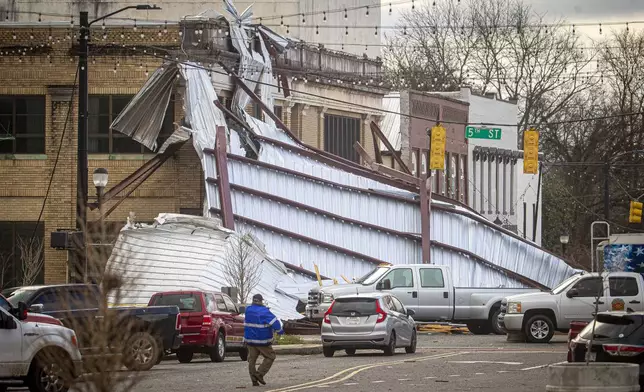 Roofing drapes over a building from a storm at the intersection of Main and Fifth Streets in downtown Tuscumbia, Ala., Sunday, Feb. 16, 2025. Dan Busey/The TimesDaily via AP)
