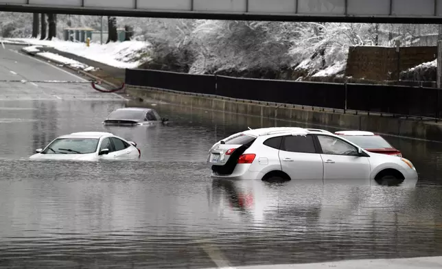 Cars sit in floodwaters at a railroad underpass in Louisville, Ky., Sunday, Feb. 16, 2025. (AP Photo/Timothy D. Easley)