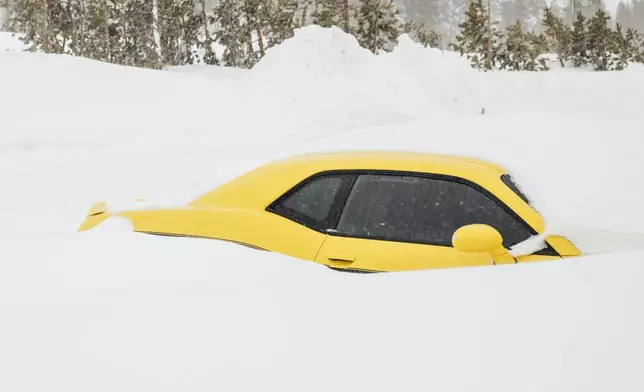 A Dodge Challenger is seen buried in snow near Soda Springs, Calif., Friday, Feb. 14, 2025. (Stephen Lam/San Francisco Chronicle via AP)