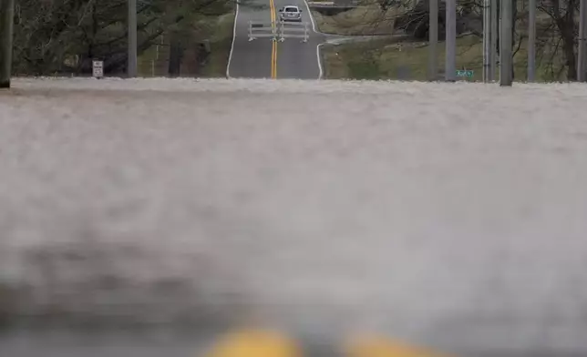 A vehicle drives the opposite direction of a road closure sign along Dunbar Cave Rd., Sunday, Feb. 16, 2025, in Clarksville, Tenn. (AP Photo/George Walker IV)