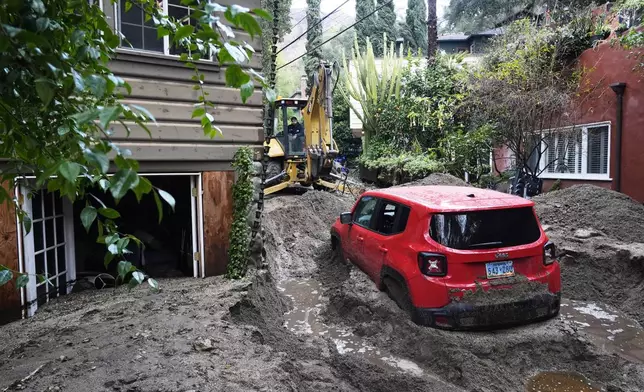 A vehicle is dug out of the mud after a storm Friday, Feb. 14, 2025, in Sierra Madre, Calif. (AP Photo/Damian Dovarganes)