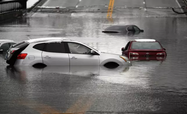 Cars sit in floodwaters at a railroad underpass in Louisville, Ky., Sunday, Feb. 16, 2025. (AP Photo/Timothy D. Easley)