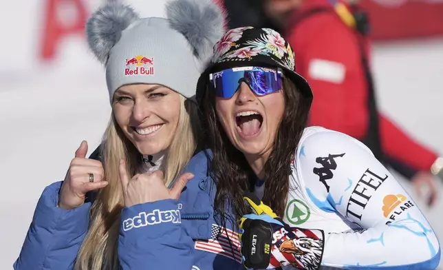 United States' Lindsey Vonn, left, shares a light moment with United States' Lauren Macuga, third-placed in a women's Super-G, at the Alpine Ski World Championships, in Saalbach-Hinterglemm, Austria, Thursday, Feb. 6, 2025. (AP Photo/Giovanni Auletta)