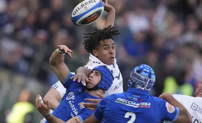 France's Mickael Guillard and Italy's Simone Gesi vie for the ball, during the Six Nations rugby union match between Italy and France at the Olympic stadium, in Rome, Sunday, Feb. 23, 2025. (Alfredo Falcone/LaPresse via AP)