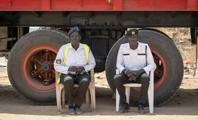 Traffic police officers sit beside the road in Juba, South Sudan Friday, Feb. 21, 2025. (AP Photo/Florence Miettaux)