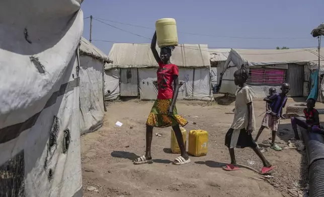 A child carries a jerry can of water on her head in Juba, South Sudan Wednesday, Feb. 12, 2025. (AP Photo/Brian Inganga)