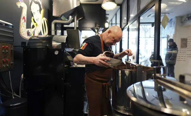 Artisan chocolatier Dominique Persoone pours cocoa beans in a machine in his workshop at The Chocolate Line in Bruges, Belgium, Thursday, Feb. 6, 2025. (AP Photo/Virginia Mayo)