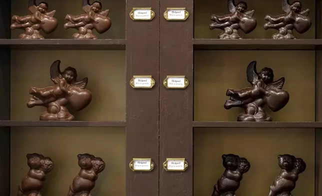 Chocolate angels and other figures for sale line a shelf at The Chocolate Line in Bruges, Belgium, Thursday, Feb. 6, 2025. (AP Photo/Virginia Mayo)