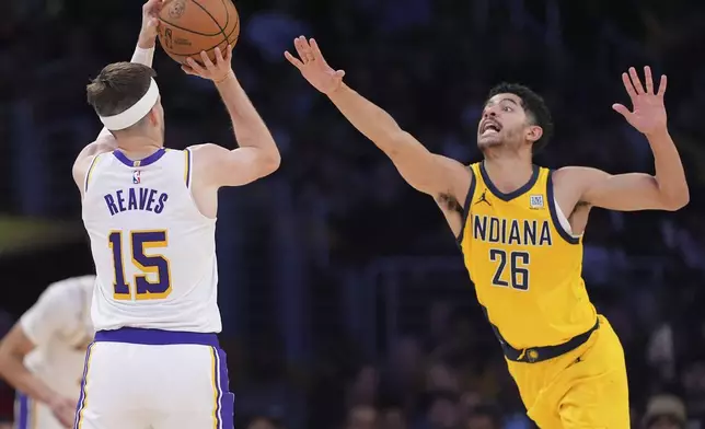 Los Angeles Lakers guard Austin Reaves, left, shoots and scores as Indiana Pacers guard Ben Sheppard defends during the second half of an NBA basketball game, Saturday, Feb. 8, 2025, in Los Angeles. (AP Photo/Mark J. Terrill)