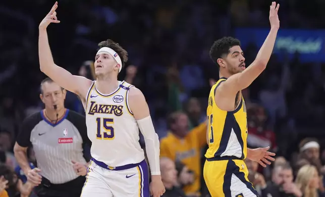 Los Angeles Lakers guard Austin Reaves, left, gestures after hitting a thee-point shot as Indiana Pacers guard Ben Sheppard stands by during the second half of an NBA basketball game Saturday, Feb. 8, 2025, in Los Angeles. (AP Photo/Mark J. Terrill)