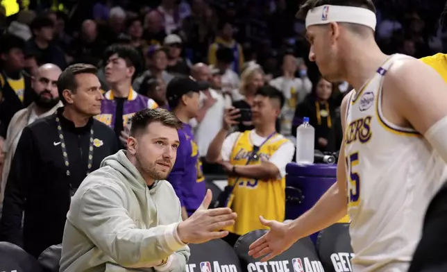 Los Angeles Lakers' Luka Doncic, left, greets guard Austin Reaves prior to an NBA basketball game against the Indiana Pacers, Saturday, Feb. 8, 2025, in Los Angeles. (AP Photo/Mark J. Terrill)