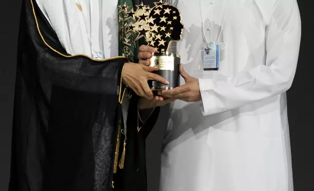 Saudi Arabian teacher Mansour bin Abdullah Al-Mansour, left, receives the Global Teacher Prize trophy from Dubai Crown Prince Sheikh Hamdan bin Mohammed Al Maktoum at a ceremony awarding the Global Teacher Prize in Dubai, United Arab Emirates, Thursday, Feb. 13, 2025. (AP Photo/Altaf Qadri)