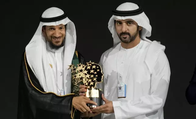 Saudi Arabian teacher Mansour bin Abdullah Al-Mansour, left, receives the Global Teacher Prize trophy from Dubai Crown Prince Sheikh Hamdan bin Mohammed Al Maktoum at a ceremony awarding the Global Teacher Prize in Dubai, United Arab Emirates, Thursday, Feb. 13, 2025. (AP Photo/Altaf Qadri)