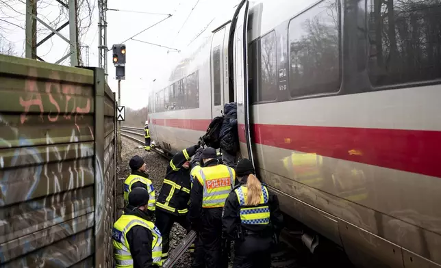 One person is evacuated from the train at the scene of an accident at a level crossing, a collision between a train and a truck, in Hamburg, Germany, Tuesday Feb. 11, 2025. (Daniel Bockwoldt/dpa via AP)