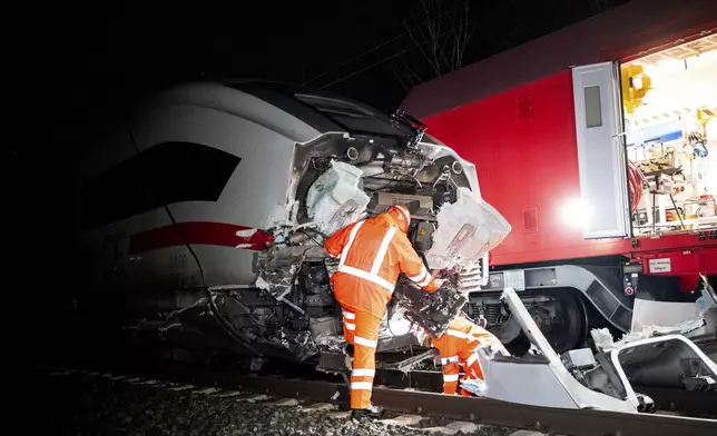 Railroad technicians work at the scene of a train accident, a collision between a train and a truck, in Hamburg, Germany, early Wednesday, Feb. 12, 2025. (Daniel Bockwoldt/dpa via AP)