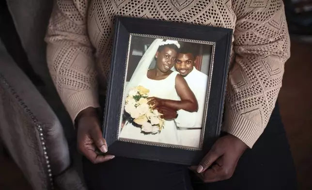 Sharline Volcy holds a photo from her wedding to Ronald Donat, on Monday, Feb. 3, 2025, in Orange, N.J. (AP Photo/Andres Kudacki)