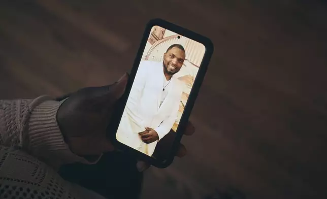 Sharline Volcy shows a picture of her husband, Ronald Donat, on Monday, Feb. 3, 2025, in Orange, N.J. (AP Photo/Andres Kudacki)