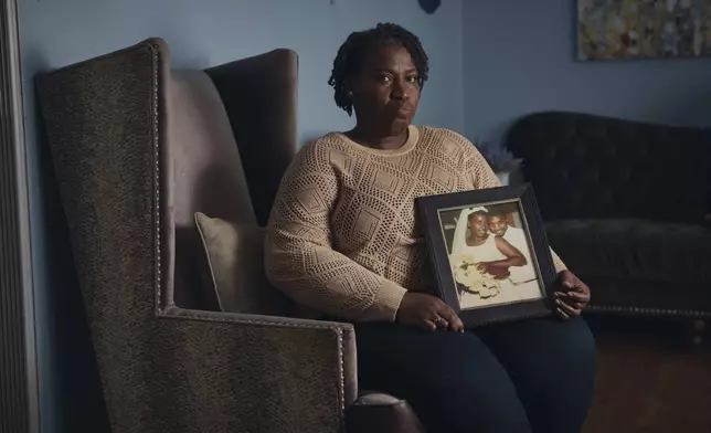 Sharline Volcy holds a wedding picture of her and her deceased husband, Roland Donat's, on Monday, Feb. 3, 2025, in Orange, N.J. (AP Photo/Andres Kudacki)