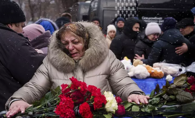 Relatives say goodbye to Dmytro Yavorskyi, 37, Sofia Yavorska, 9, Olena Yavorska 38, who were killed on Feb. 1 by a Russian strike on residential building during a funeral ceremony in Poltava, Ukraine, Wednesday, Feb. 5, 2025. (AP Photo/Evgeniy Maloletka)