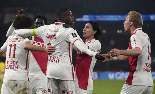 Monaco's Denis Zakaria celebrates with teammates after scoring his sides first goal during the French League One soccer match between Paris Saint-Germain and Monaco at Parc des Princes stadium in Paris, Friday, Feb. 7, 2025. (AP Photo/Michel Euler)
