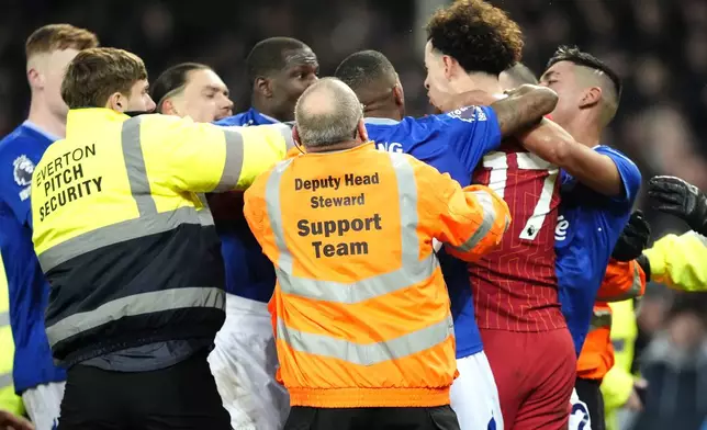 Liverpool's Curtis Jones, second from right, and Everton's Abdoulaye Doucoure are separated by teammates and members of the ground staff following a clash after the final whistle in a Premier League soccer match at Goodison Park, Wednesday, Feb. 12, 2025, in Liverpool. (Nick Potts/PA via AP)