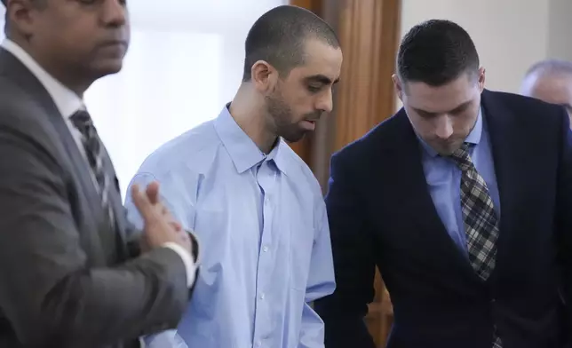 Hadi Matar, center, stands at the defense table with his attorneys before the start of the second day of his trial at the Chautauqua County Courthouse, Tuesday, Feb. 11, 2025, in Mayville, N.Y. Matar is charged with stabbing famed author Salman Rushdie. (AP Photo/Gene J. Puskar)