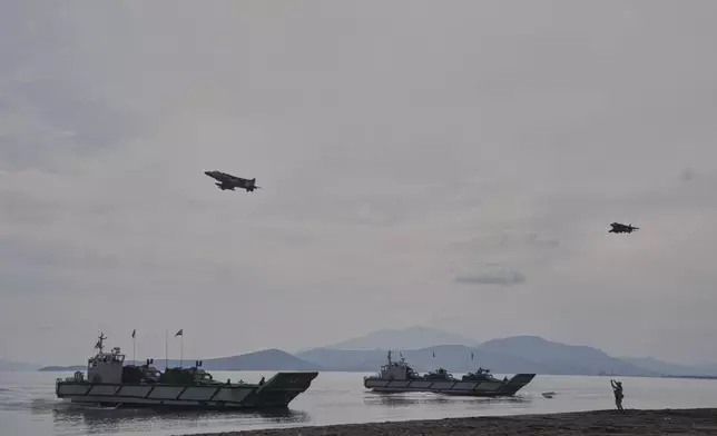 Special forces from Spain land on a beach while a Harriet , left, and an F16 fighter jets fly as the participate in the Steadfast Dart 2025 exercise, involving some 10,000 troops in three different countries from nine nations and represent the largest NATO operation planned this year, in Nea Anchialos, central Greece, Thursday, Feb. 13, 2025. (AP Photo/Thanassis Stavrakis)