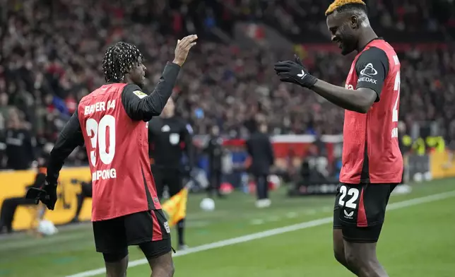 Leverkusen's Jeremie Frimpong, left, celebrates with Leverkusen's Victor Boniface after he scored his side's second goal during the German Bundesliga soccer match between Bayer Leverkusen and TSG Hoffenheim at the BayArena in Leverkusen, Germany, Sunday, Feb. 2, 2025. (AP Photo/Martin Meissner)