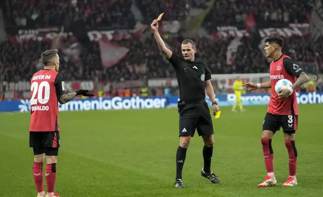 Referee Robin Braun shows the red card to Leverkusen's Alex Grimaldo during the German Bundesliga soccer match between Bayer Leverkusen and TSG Hoffenheim at the BayArena in Leverkusen, Germany, Sunday, Feb. 2, 2025. (AP Photo/Martin Meissner)