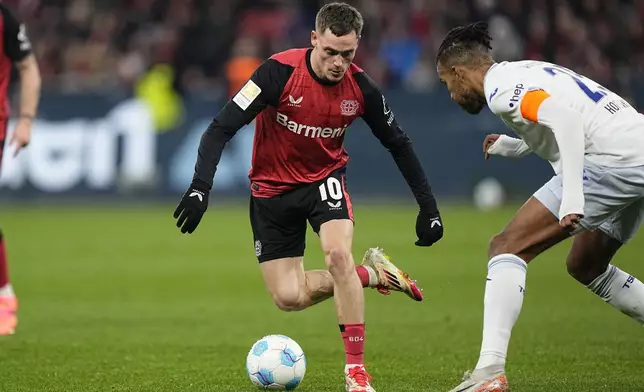 Leverkusen's Florian Wirtz and Hoffenheim's Kevin Akpoguma challenge for the ball during the German Bundesliga soccer match between Bayer Leverkusen and TSG Hoffenheim at the BayArena in Leverkusen, Germany, Sunday, Feb. 2, 2025. (AP Photo/Martin Meissner)