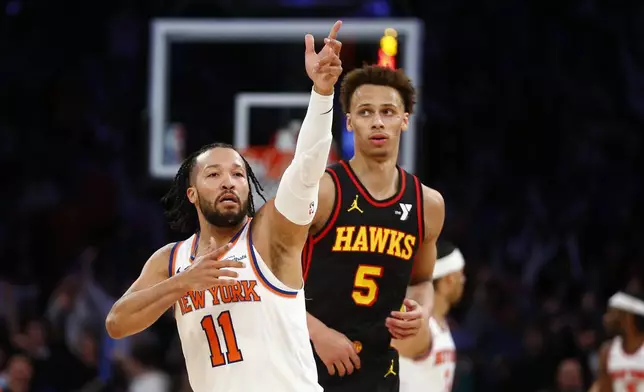 New York Knicks guard Jalen Brunson (11) reacts after making a three-point basket in front of Atlanta Hawks guard Dyson Daniels (5) during the second half of an NBA basketball game Wednesday, Feb. 12, 2025, in New York. (AP Photo/John Munson)