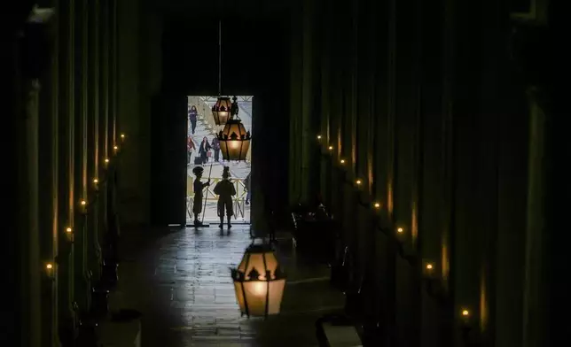 Vatican Swiss guards surveil the Bronze Door, the main entrance to the papal apartments, at The Vatican, Sunday, Feb. 23, 2025, as Pope Francis who was admitted over a week ago at Rome's Agostino Gemelli Polyclinic is in critical conditions. (AP Photo/Alessandra Tarantino)