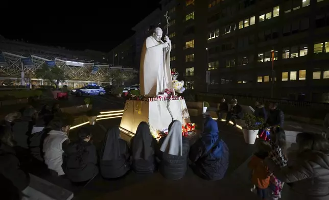 People pray for Pope Francis in front of the Agostino Gemelli Polyclinic, in Rome, Sunday, Feb. 23, 2025, where the Pontiff is hospitalized since Friday, Feb. 14. (AP Photo/Andrew Medichini)