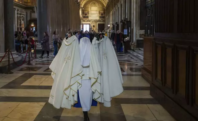 A nun carries tunics inside the Santa Maria Maggiore Basilica in Rome, Tuesday, Feb. 25, 2025. (AP Photo/Bernat Armangue)
