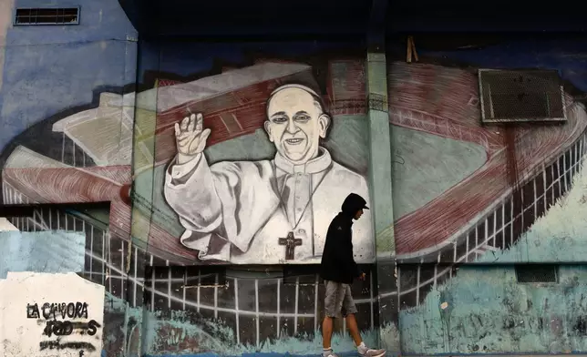 A man walks past a mural of Pope Francis at the stadium of San Lorenzo, his soccer team, in the Padre Ricciardelli neighborhood of Buenos Aires, Argentina, Tuesday, Feb. 25, 2025. (AP Photo/Rodrigo Abd)