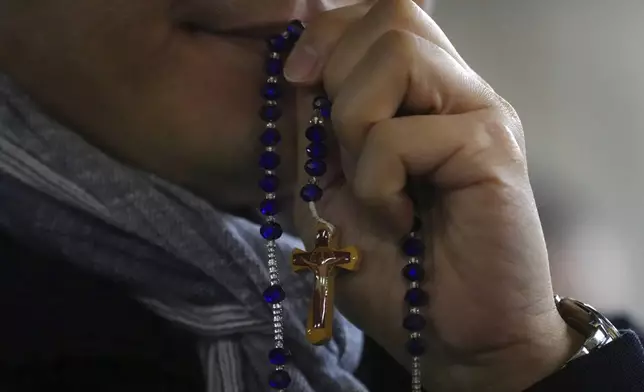 A man attends a rosary prayer service with Cardinal Luis Antonio Tagle held for the health of Pope Francis in St Peter's Square at The Vatican, Tuesday, Feb. 25, 2025. (AP Photo/Kirsty Wigglesworth)